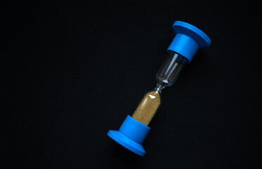 Glass hourglass on black isolate