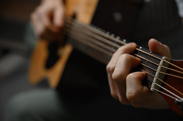 Fototapeta premium Man playing acoustic guitar, cover for online courses, learning at home.