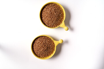 Top view of buckwheat in the bowls isolated on white background, with copy space.