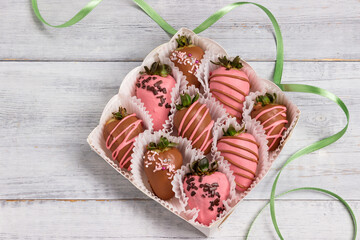 Chocolate covered strawberries in a box on a wooden table.