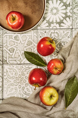 Ripe red apples  with leaves on rustic tile.Top view.