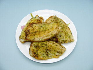 Tilapia fish fillet fried with spices. A shared plate. Many.