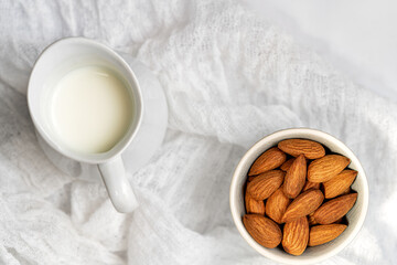 Vegan almond milk in jud and almond on white napkin.Top view with copy space.