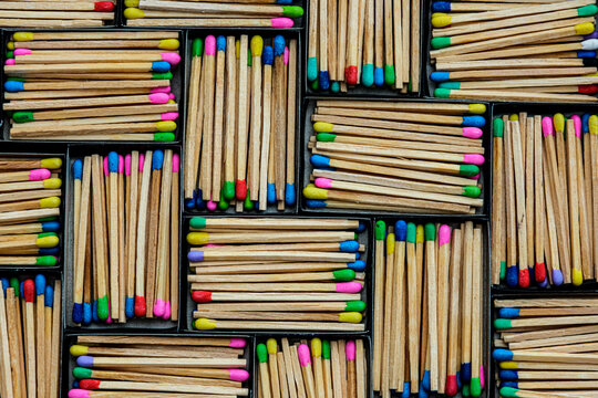 multicolored match sticks in boxes on a black background