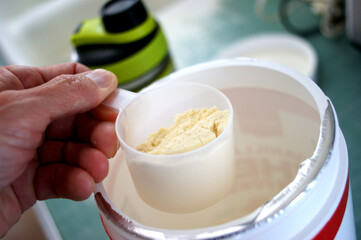 Person holding scoop of protein powder
