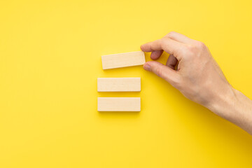 blank wooden blocks stack over yellow background. business strategy template. step notes mockup. above view