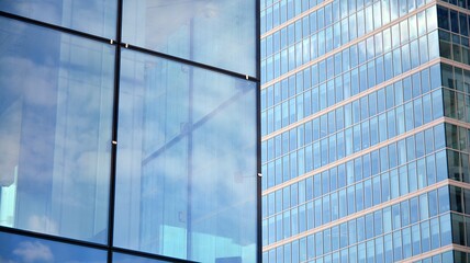 Glass clad facade of a modern building covered in reflective plate glass.