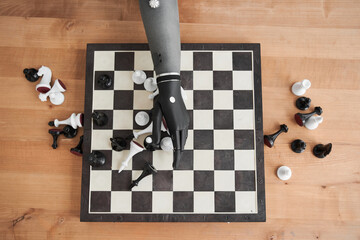 Engineer holding chess piece with black bionic hand while playing at the chess
