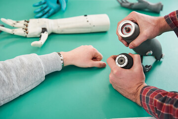 Two scientists examining mechanical hand in laboratory
