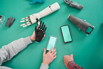People holding plastic hand and looking something at the smartphone
