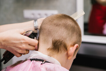 Children's haircut for a boy.Stylish and fashionable hairstyle.Hair care of the child.