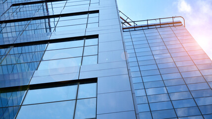 Obraz premium Glass clad facade of a modern building covered in reflective plate glass.