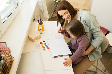 Girl with down syndrome creating a masterpiece at home