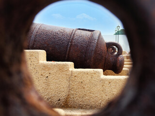 Close up view to the old powder cannon through the hole. Zanzibar, Tanzania.