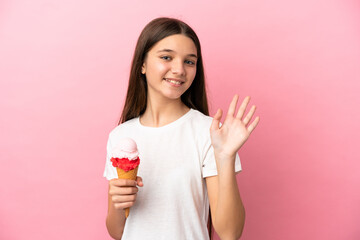 Little girl with a cornet ice cream over isolated pink background saluting with hand with happy expression