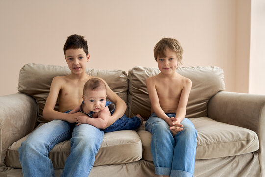 Family photo of three boys. Three brothers pose on the sofa. High quality photo