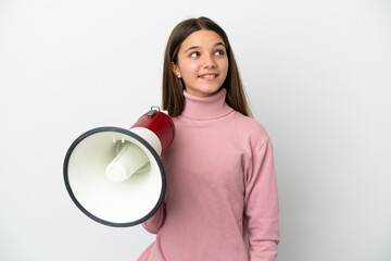 Little girl over isolated white background holding a megaphone and looking up while smiling
