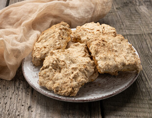 square baked cookie pieces lie in a round plate on the table, polish cookies