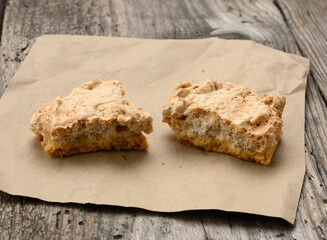 square baked cookie pieces lie on a piece of paper, wooden gray table, polish cookies