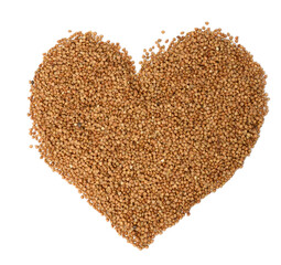 heap of uncooked buckwheat grains, top view. Groats laid out in the shape of a heart