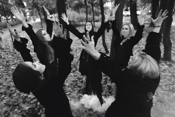 Coven of witches, a group of friends as witches on Halloween perform a ritual, lead a round dance...