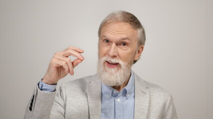 Fototapeta premium Cheerful man snapping fingers inside. Aged businessman looking camera indoors.