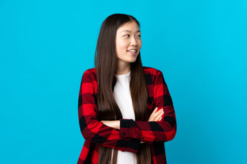 Young Chinese girl over isolated blue background happy and smiling