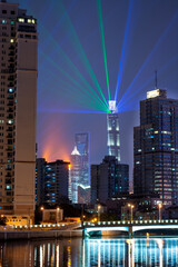 Shanghai,China - 11.04.2019: Shanghai light show at night to international import and export expo ciie 2019 with residential buildings in the foreground and skyscraper in the background