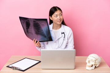 Professional Chinese traumatologist in workplace laughing and looking up