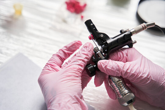 Artist Wearing Protective Pink Medical Gloves Assembling A Tattoo Machine