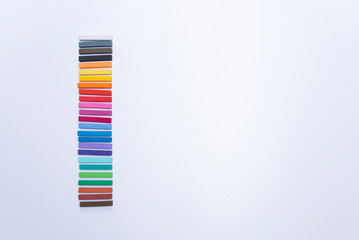 GROUPS OF COLORED CHALKS IN PILES ON A WHITE BACKGROUND