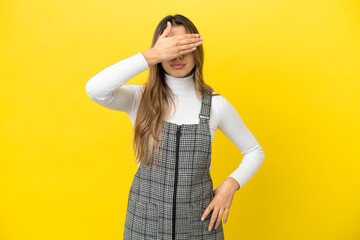 Young caucasian woman isolated on yellow background covering eyes by hands. Do not want to see...