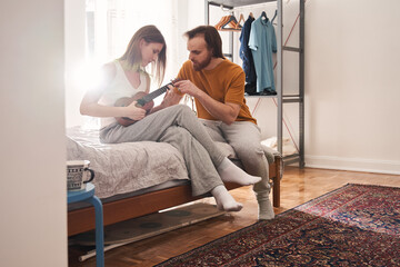 Obraz premium Man helping to his girlfriend with playing at the ukulele