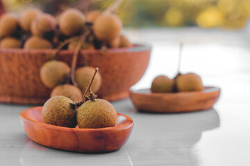 longan fruit on a coconut wood plate.