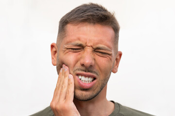 Young man face suffering from strong tooth pain with or toothache. Teeth problem. Man feeling tooth pain