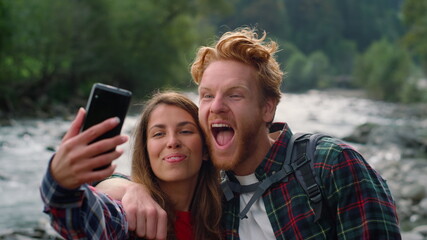 Couple taking selfie on smartphone. Woman and man making funny faces 