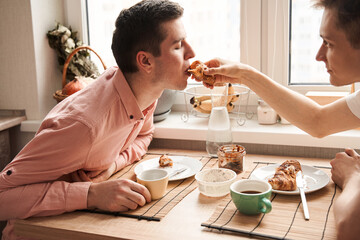 Two gay men having breakfast at the kitchen at the morning