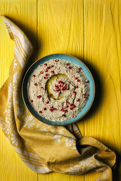 Baba ganoush or mutabal, Middle Eastern eggplant dip sauce garnished with pomegranate seeds with a rustic napkin