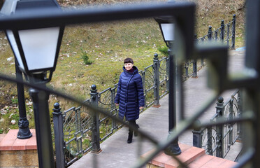 a woman walks on a bridge 