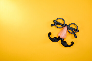 Top view of a nose and mustache glasses isolated on yellow background with copyspace