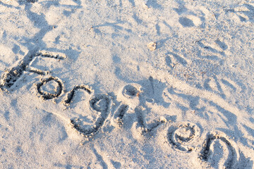 word forgiven written in sand
