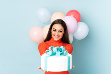 Young woman with many balloons isolated on blue background