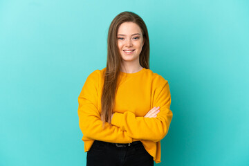 Teenager girl over isolated blue background keeping the arms crossed in frontal position