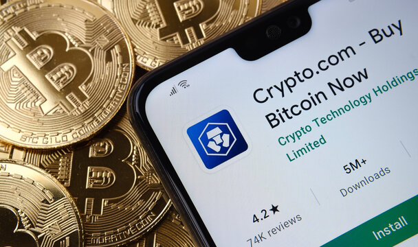 Crypto.com app seen on the smartphone screen placed on top bitcoin coins pile. Concept. Stafford, United Kingdom, April 12, 2021.
