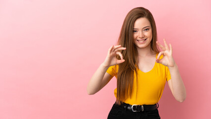 Teenager girl over isolated pink background showing ok sign with two hands
