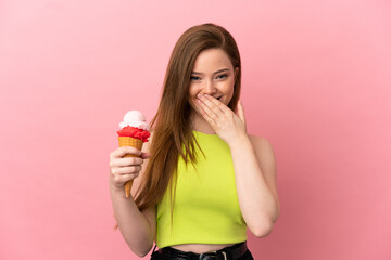 Teenager girl with a cornet ice cream over isolated pink background happy and smiling covering mouth with hand