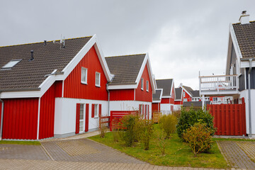Fototapeta na wymiar Red wooden houses in Sweden. Swedish houses on a street. Vacation in Sweden