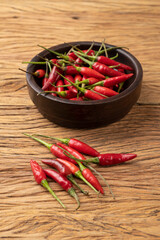 Red malagueta chili peppers on a bowl over wooden table
