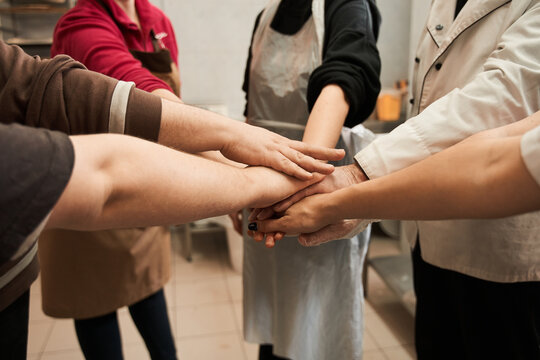 Bakery team keeping hands together as a symbol of unity while working together