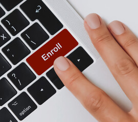 Computer keyboard showing words Enroll.